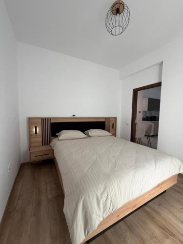 a white bedroom with a large bed and a mirror at Apartament DAR25 in Sînmartin