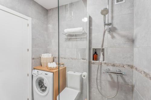 een badkamer met douche en wasmachine bij Yucca Park 1 Bed Apartment in Adeje
