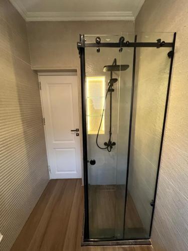 a shower with a glass door in a room at Sela 1 in Cairo