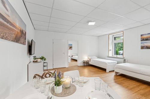 a white living room with a table and a couch at For Workers Bedburg Hau in Bedburg Hau