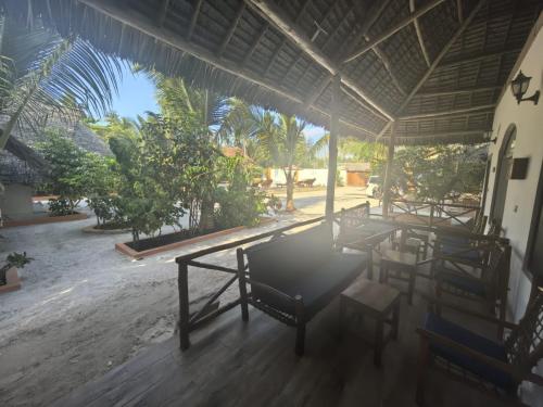 a group of tables and chairs in a building at Sunset Mkuu Boutique Hotel in Michamvi
