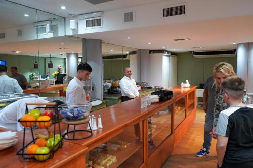 Un grupo de personas de pie alrededor de un mostrador en una cocina. en Hotel Facon Grande, en Buenos Aires