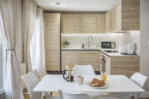 a white table with a plate of food on it in a kitchen at Bright 1 bedroom apartments near Farnham Castle in Hurley