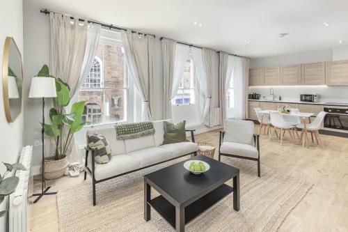 a living room with a couch and a table at Bright 1 bedroom apartments near Farnham Castle in Hurley