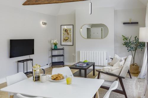 a living room with a white table and chairs at Bright 1 bedroom apartments near Farnham Castle in Hurley