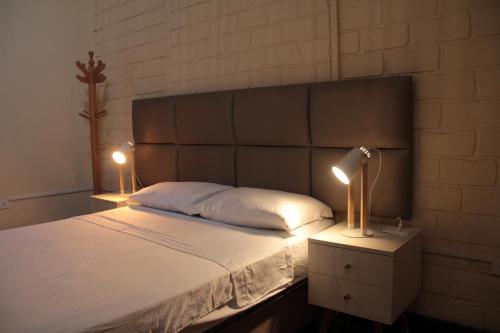 Un dormitorio con una cama con dos lámparas encima. en Ancestral Lima Downtown, en Lima