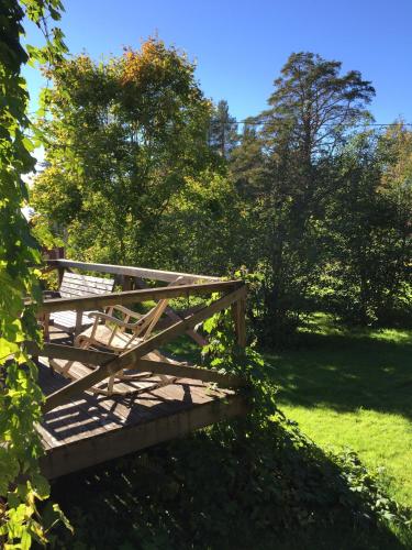 a wooden bridge in a field with trees at Villa Insikt Pensionat & Kursgård in Burträsk