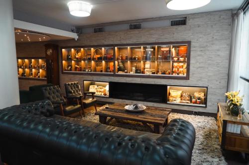 a living room with a leather couch and a fireplace at Hotel Facon Grande in Buenos Aires