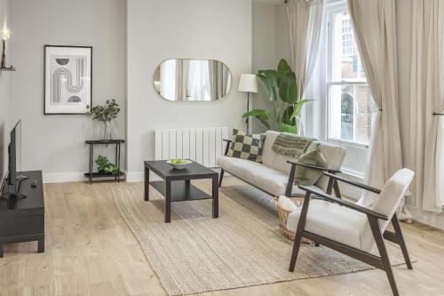 a living room with a couch and a table at Bright 1 bedroom apartments near Farnham Castle in Hurley