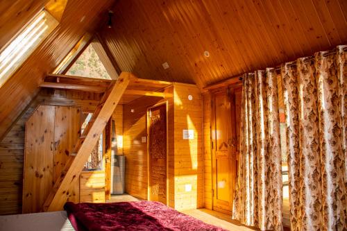 1 dormitorio en una cabaña de madera con cama y ventana en Palach Kothi, en Banjār