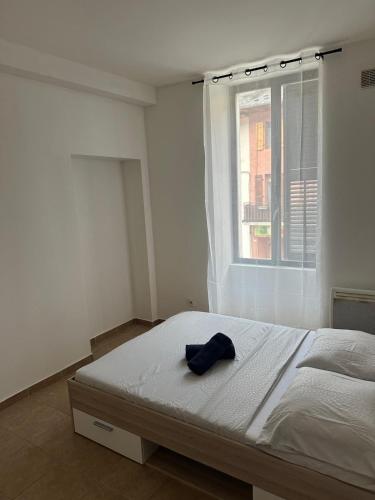 a white bedroom with a bed with a window at Beau T3 in Aiguebelle