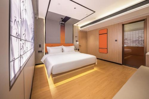 Un dormitorio con una cama y un cuadro en la pared. en Guilin Meiju Lishui Hotel, en Yangshuo