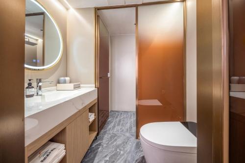 un baño con inodoro y lavabo en Guilin Meiju Lishui Hotel, en Yangshuo