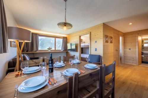a dining room with a large wooden table and chairs at SWISSPEAK Resorts by Pierre & Vacances Premium Vercorin in Vercorin