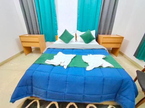 een slaapkamer met een blauw bed en 2 handdoeken bij Villa Portuguesa 5 bhk calangute in Calangute