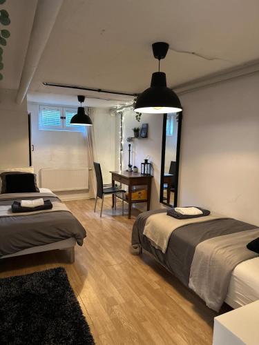 a bedroom with two beds and a desk and a table at Charming apartment with industrial design close to city center in Växjö