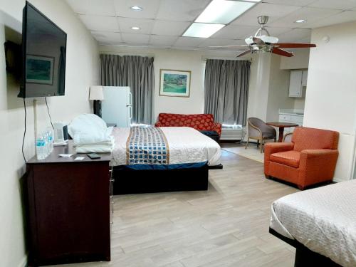 a hotel room with two beds and a flat screen tv at Budgetel Inn and Suites- FORT GORDON in Augusta
