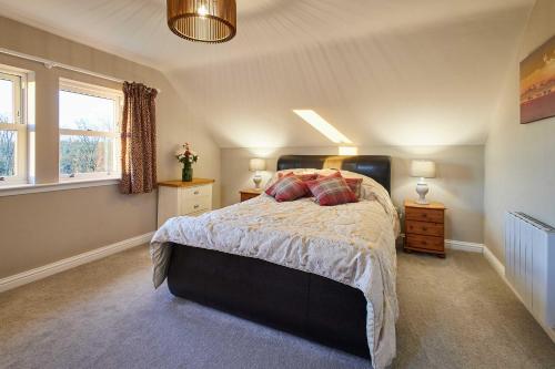 a bedroom with a large bed and two windows at Host & Stay - Carterhouse in Jedburgh