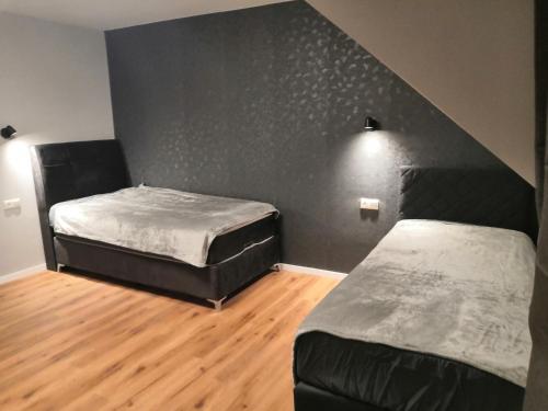 two beds in a room with a black wall at Schöne Ferienwohnung in Schwerte Central in Schwerte
