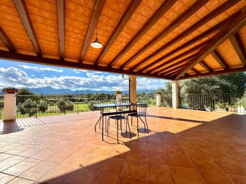 Un patio con una mesa y sillas. en Cronta Apartments, en Bari Sardo