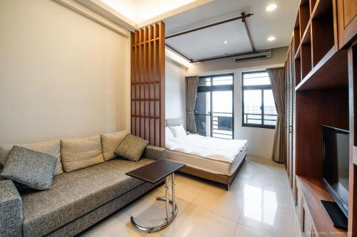 a living room with a couch and a bed at 謙匯國際酒店式公寓 CH Service Apartment in Taipei