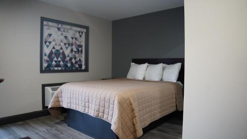 ein Schlafzimmer mit einem Bett mit einer weißen Tagesdecke in der Unterkunft Best Way Inn in Middlefield