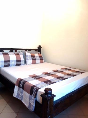 Un dormitorio con una cama con una manta a cuadros. en Escaped Diani, en Diani Beach