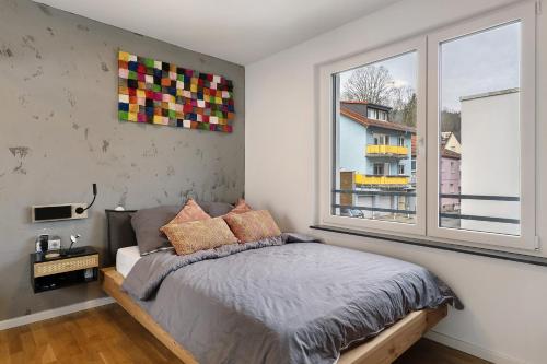 Willkommen in Ihrem Luxus-Penthouse في Ziegelhausen: غرفة نوم بها سرير ونافذة كبيرة