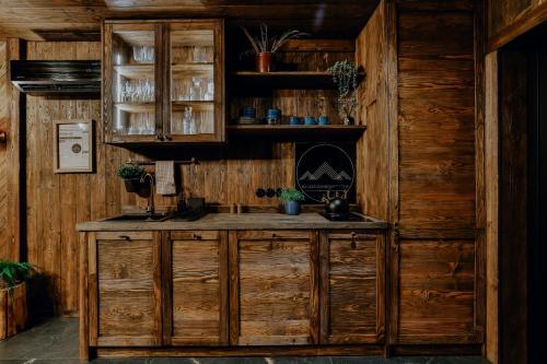 een keuken met houten kasten en een aanrecht in een kamer bij Na Gorczańskim Wierchu, sauna i balia na wyłączność in Rabka