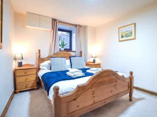 a bedroom with a wooden bed and a window at 2 Bed in Newton-on-Rawcliffe 88955 in Newton