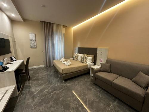 una habitación de hotel con una cama y un sofá en DEDA & FOVE, en Nápoles
