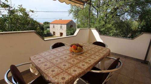 a table with a bowl of fruit on a balcony at Apartment Malinska, Primorje-Gorski Kotar 20 in Sveti Vid-Miholjice