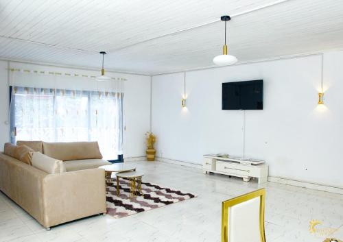 a living room with a couch and a tv at Maison moderne et spacieuse 9 min Ivato aeroport 
