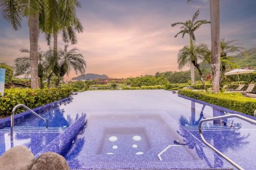 a pool at a resort with palm trees at Vista Bahia 1G - 3bed 3 bath Ocean View in La Mona