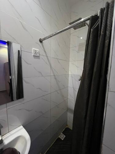 un baño con ducha y lavabo en Maxwells Inn Yaba, en Lagos