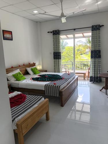 two beds in a room with a window at Hotel Sapid Luck Yala Safari in Tissamaharama