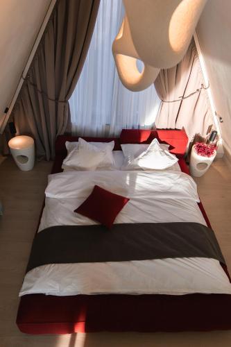 a bed with red and white pillows in a room at Twin Vista A-Frame Cabins in Sovata
