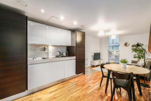 a kitchen and dining room with a table in a room at The Lambs Passage Executive Apartment in London