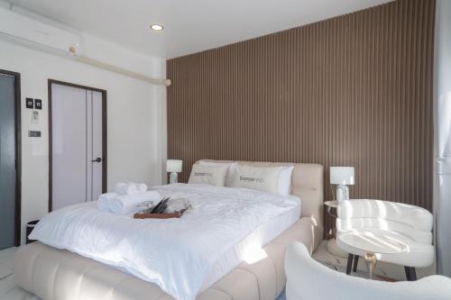 a bedroom with a large white bed and a chair at ฌอณบูติค Shon Boutique in Ban Nong Nam Khan