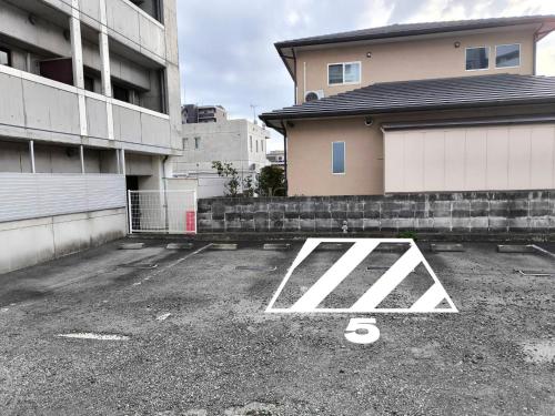 un estacionamiento frente a un edificio en vetta KumamotoCastle1003 Free Parking, en Kumamoto