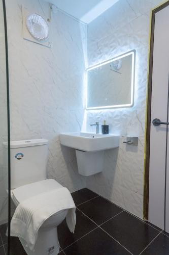 a white bathroom with a toilet and a sink at ฌอณบูติค Shon Boutique in Uthai Thani