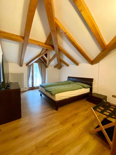 Appartamento Vittoria في كليس: غرفة نوم بسرير في غرفة ذات أرضيات خشبية