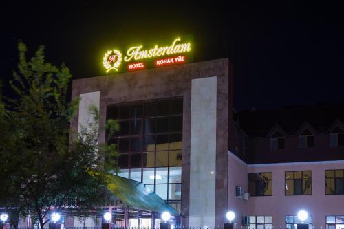 a building with a sign on top of it at Amsterdam Hotel Aktobe in Aktobe