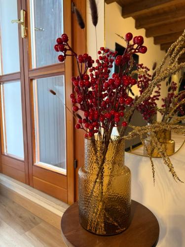 a vase with red flowers sitting on a table at casa duomo vicenza in Vicenza