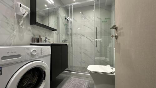 a bathroom with a washing machine and a shower at Casa Aphrodite Thessaloniki in Thessaloniki