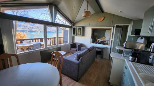 eine Küche und ein Wohnzimmer mit Sofa und Tisch in der Unterkunft La perle du lac - Némausa location in Chorges