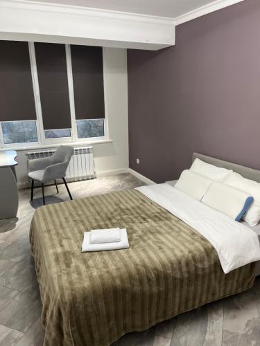 CăuşeniにあるApartament modernの大きなベッドと椅子のある寝室