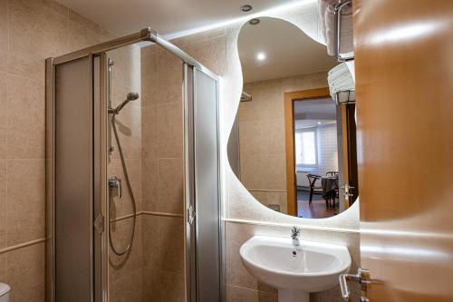 a bathroom with a sink and a shower with a mirror at Hotel Rural El Majuelo in Montorio