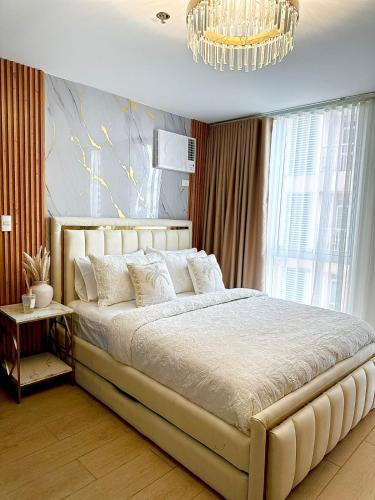 a bedroom with a large bed and a chandelier at Modern 1 bedroom spacious apartment with Venice Grand Canal View in Manila