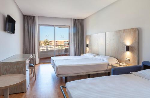 a hotel room with two beds and a balcony at AGH Canet in Canet de Berenguer